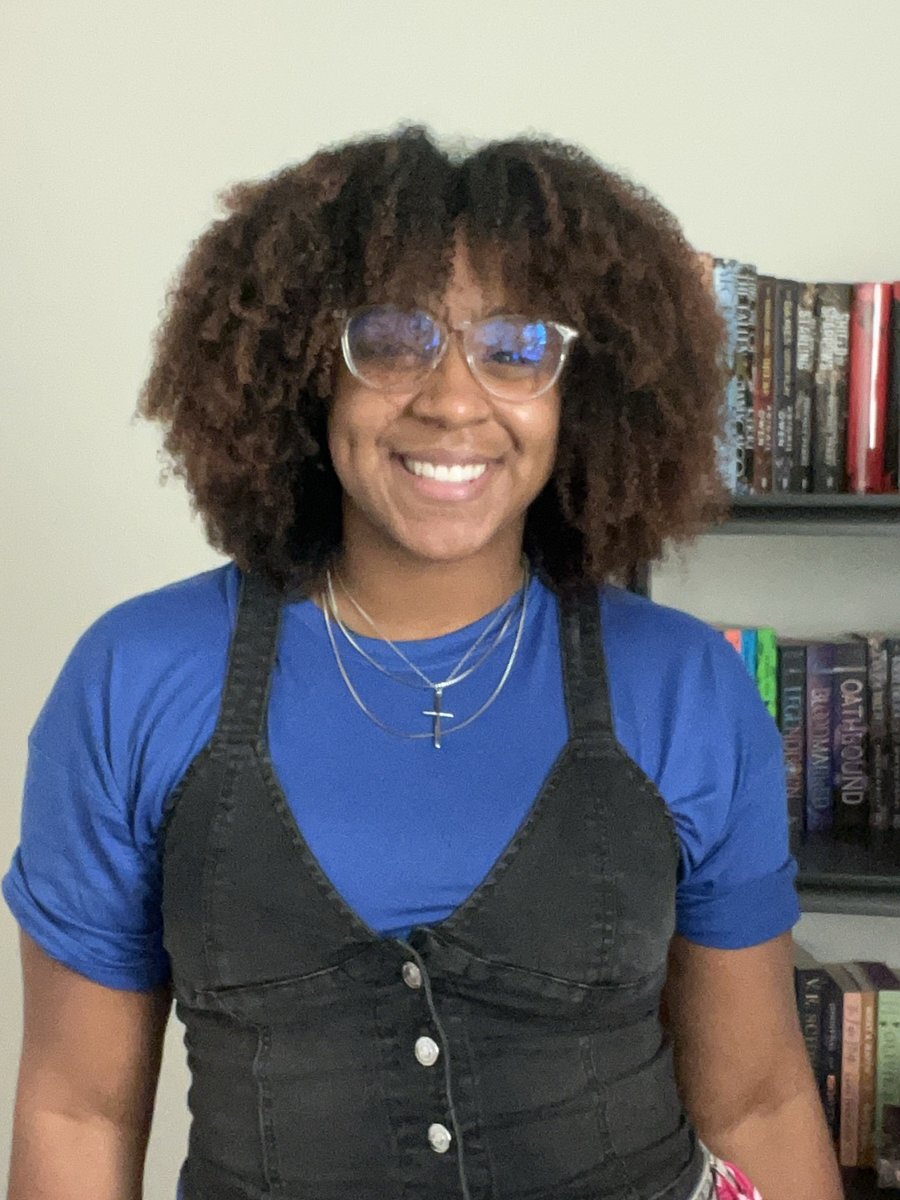 Jaitesha Hanson, LMHC, smiling in front of her bookshelf